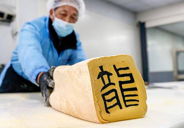 Jin Huimin, an inheritor of the making crafts of character-inlaid candy, makes the candy in Qimen County of Huangshan City, east China's Anhui Province, Jan. 31, 2024. (Xinhua/Cao Li)