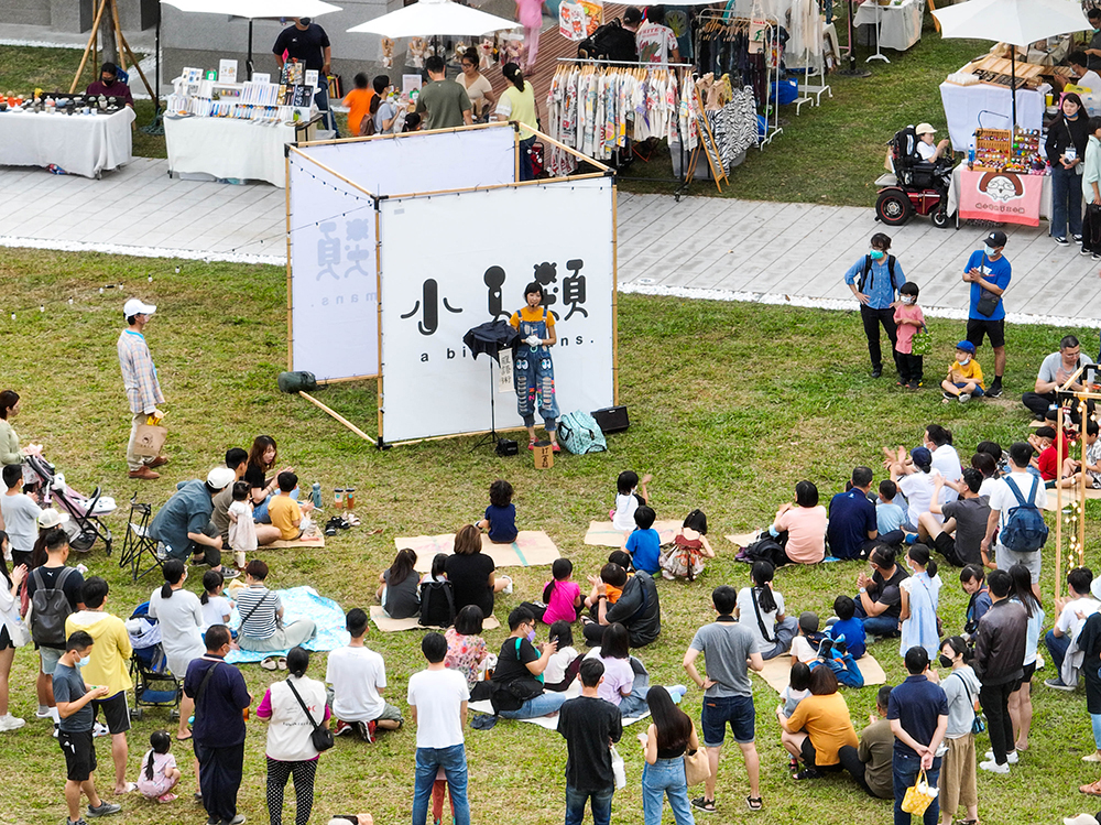 台塑王氏昆仲公園正式對外開放，民眾坐在大草坪上欣賞演出。(圖片提供/財團法人高雄市王永慶、王永在昆仲公園文化基金會)