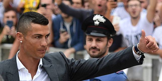 Pemain baru Juventus, Cristiano Ronaldo, melambaikan tangan kepada para suporter saat tiba untuk melakukan tes medis di markas klub di Stadion Allianz, Turin, Senin (16/7/2018).