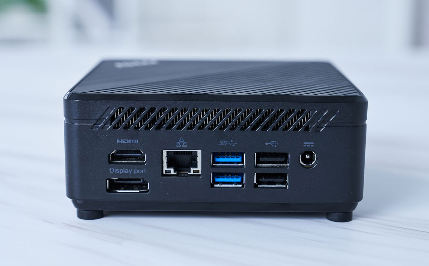 機身背面配置了大面積的散熱孔，更多連接埠也配置於虎，包括電源接口、兩組 USB 2.0 A 埠、兩組 USB 3.2 Gen1 A 埠、一組 RJ-45 乙太網路孔、以及 HDMI 與 DisplayPort 雙視訊輸出埠。