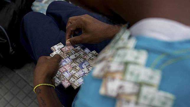 Saking tidak berartinya, warga Venezuela lebih memilih membuat uang kertas jadi kesenian. (AFP Photo/Federico Parra)