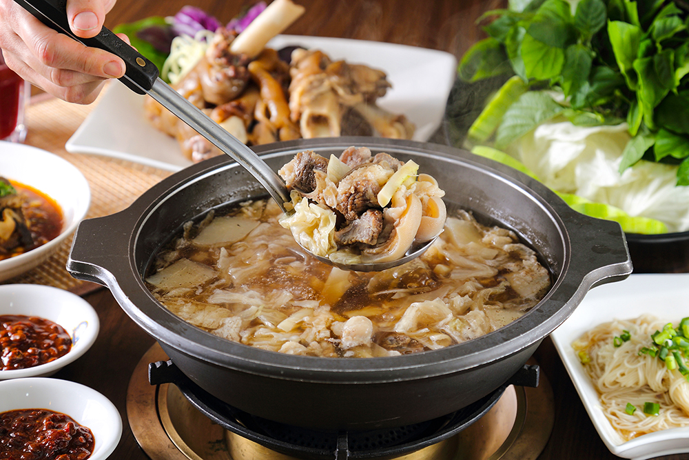 高湯只用了老薑熬煮，並加入自己醃製的筍片和高麗菜增鮮，除了羊蹄、羊頭和中腹三層肉以外的全羊精華，都濃縮在這鍋羊肉爐裡。(攝影/Carter)