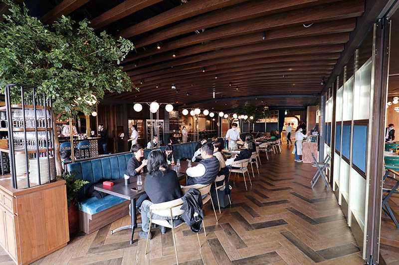 Wildwood的用餐空間運用綠樹及路燈造型的燈飾，營造休閒氛圍。（圖／于魯光）