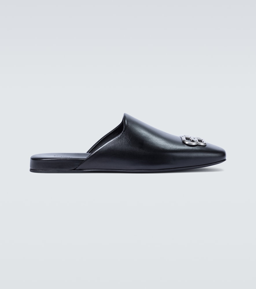 These black slip-on mules from Balenciaga are crafted from smooth leather, have a squared toe, and a