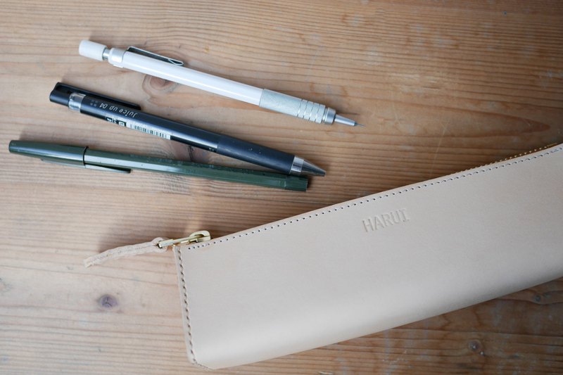 三角型筆袋升級拉鍊款 加上了皮提把好拉好關 可以快速開閤收納文具 不僅是俐落的拉鍊筆袋 也適合收納長型小物喔 現場可自由打上專屬英文字母或數字喔 尺寸：20 x 5.5 x 5 cm