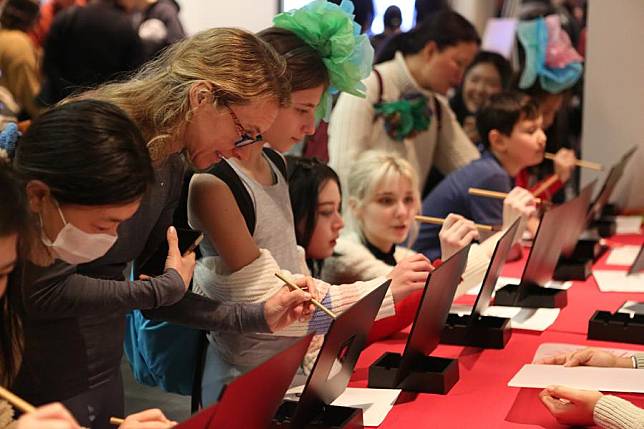 Visitors learn Chinese calligraphy during a Lunar New Year celebration event at the Metropolitan Museum of Art in New York, the United States, on Feb. 3, 2024. (Xinhua/Zhang Fengguo)