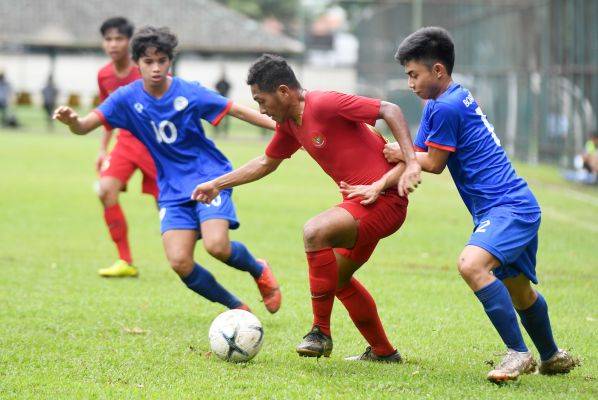 Pesepak bola Indonesia M. Fajar Fatur (kedua kanan) berusaha melewati dua pesepak bola Filipina Raphael Santos (kedua kiri) 