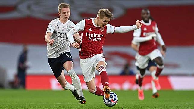 Pemain Manchester City Oleksandr Zinchenko, membayangi gelandang Arsenal Martin Odegaard dalam pertandingan Liga Inggris di Stadion Emirates, London, 21 Februari 2021. Pool via REUTERS/Shaun Botterill