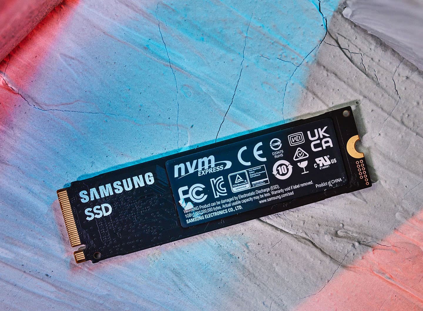 背面則有醒目的 Samsung SSD 文字，並貼了一張稍微有些厚度的銅材質散熱貼紙，上頭是各類型的安規認證標章。
