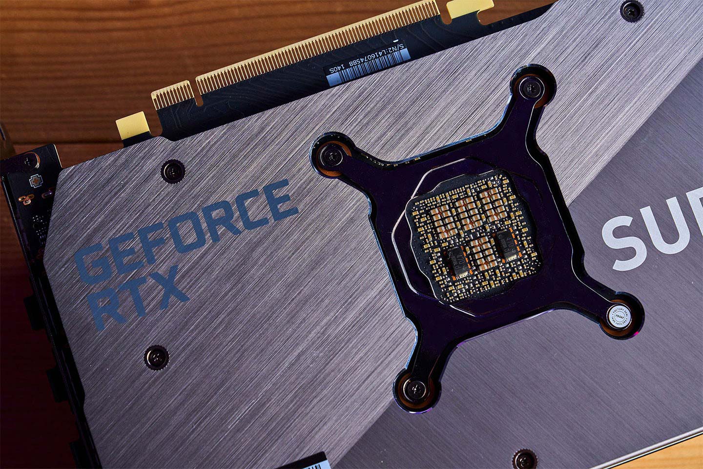 背面在光線映照下有著犀利的斜向髮絲紋路，同時也能看到 GPU 背面的電容佈局。