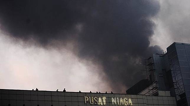 Sejumlah orang terlihat di atap gedung di dekat lokasi kebakaran di Arena Pekan Raya Jakarta, JIEXPO Kemayoran, Jakarta, Selasa, 5 Juni 2018. Gedung yang terbakar merupakan gedung gedung Convention and Theater JIExpo yang sedang dalam pengerjaan. ANTARA/Akbar Nugroho Gumay