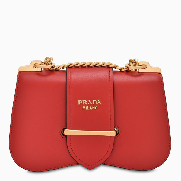 Sidonie cross-body bag by Prada in red Saffiano leather featuring sliding metal chain shoulder strap with leather shoulder pad, flap closure with strap and metal loop, inside pocket and metal lettering logo. Fall/Winter 2019-20 collection.