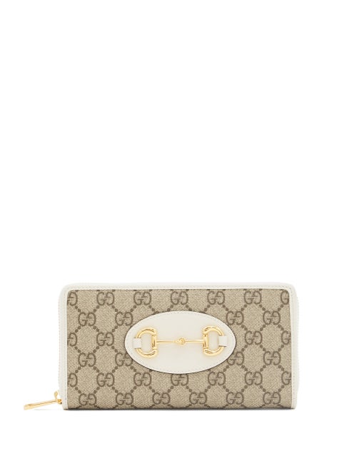 Gucci - Gucci's 1955 Horsebit adorns the front of this beige wallet paying homage to the house's origins in saddlery and luggage. It's crafted in Italy from the iconic GG Supreme canvas trimmed with white leather for a sleek aesthetic and opens to a compartmentalised interior ideal for holding cards, notes and coins. Slip it in a coordinating bag to channel the illustrious heritage.