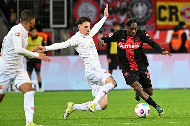 Jeremie Frimpong ® of Bayer 04 Leverkusen vies with Anthony Caci of FSV Mainz 05 during their Bundesliga match in Leverkusen, Germany, Feb. 23, 2024. (Photo by Ulrich Hufnagel/Xinhua)