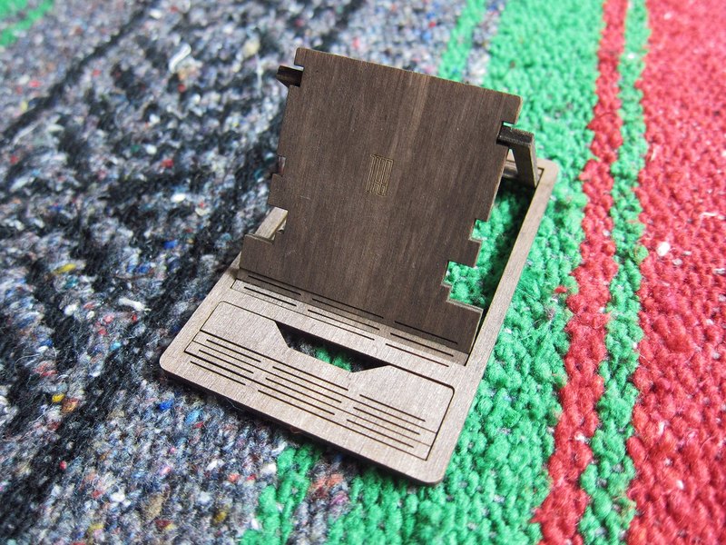 【商品簡介】 以原木為素材，利用木頭紋理與韌性，採用獨特切割路徑，讓木頭變得柔軟且富有彈性，作為此隨身手機架的翻折結構，將會幫助您撐起手機好好陪著您。 尺寸輕巧可以放進短/長皮夾裡，隨身攜帶沒煩腦，外