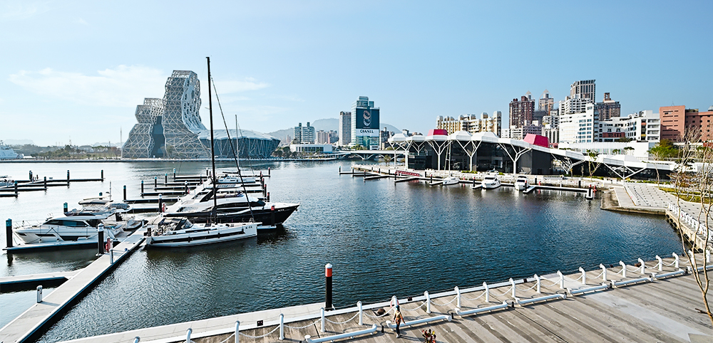 登上鯨魚堤岸的綠化景觀台，可見高雄流行音樂中心的音浪塔、珊瑚礁群及遊艇碼頭。(攝影/Carter)