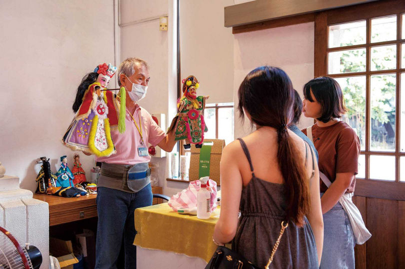 現場志工親自示範布袋戲偶，並一一說明獨特造型美學。（圖／宋岱融攝）