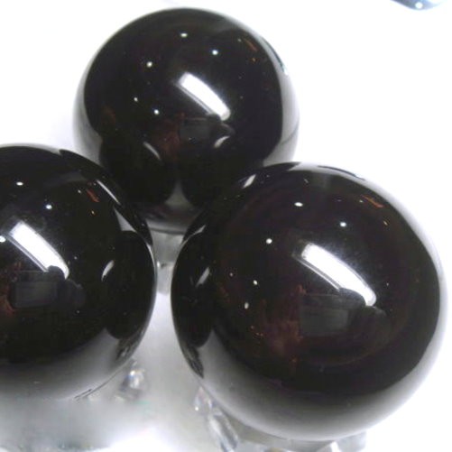 天然黑曜石球又黑又亮~還帶眼打燈後全為天地眼特色:超級正能量~開運.鎮宅.避邪.擋煞還可防小人及排穢氣~又稱:黑金剛武士＊超特惠＊約46~47mmX1顆還送壓克力底座表面如圖有一些白色火山灰及礦紋都均