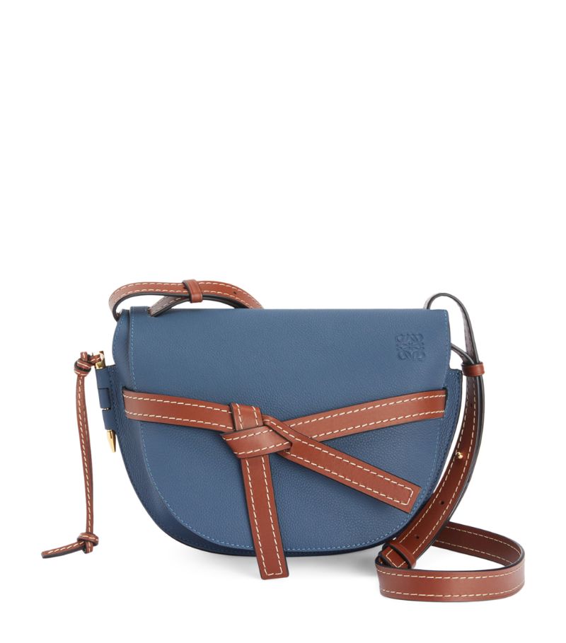 Owing its name to the side-latched pin and knotted front belt closure, the coveted Gate bag from LOEWE reimagines timeless functionality with the Spanish Houses distinct contemporary aesthetic. Encompassing the labels equestrian theme by taking on a saddle-shaped silhouette, the cross-body design is handcrafted in smooth leather to retain its structured profile, while the iconic Anagram is embossed to the front for a sleek and instantly recognisable finish.