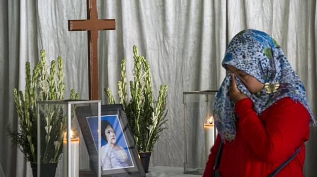 Yuli Elina (berjilbab) menangis di hadapan peti mati sahabatnya, Sri Puji Astutik, korban aksi bom bunuh diri di Gereja Pantekosta Pusat Surabaya. [Juni Kriswanto/AFP]