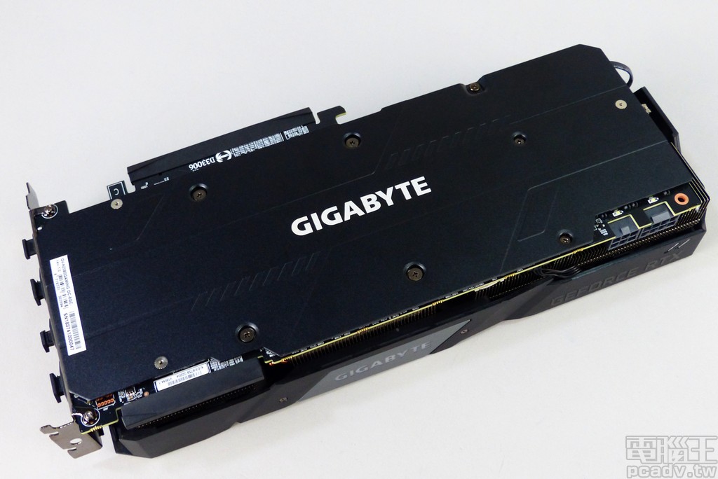 顯示卡電路板背部安裝金屬強化保護背板，並印上 GIGABYTE 商標與沖壓多邊形