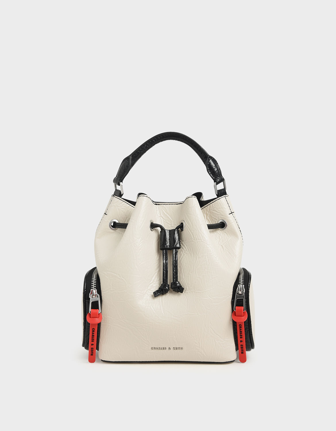 黑白雙色的俐落感，搭配皺褶材質的獨特感以及紅標籤拉鍊的搶眼特質，打造出簡約卻充滿性格的單品。