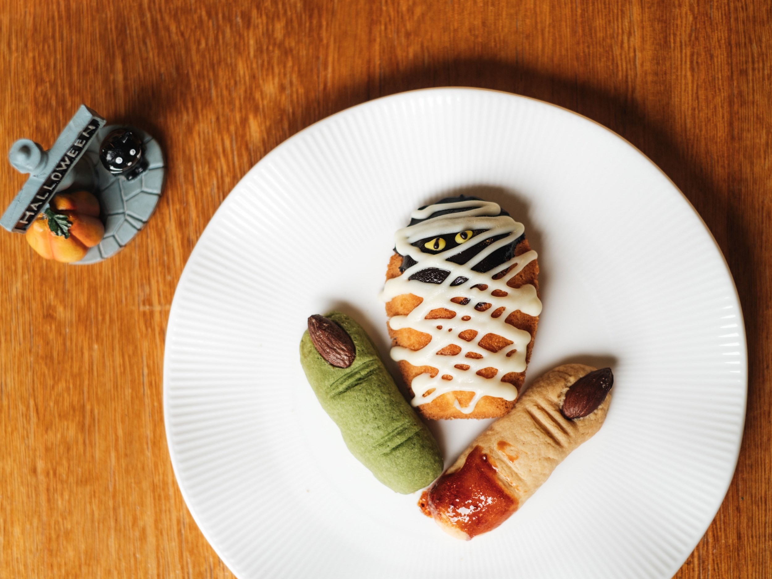 老爺小花園10/28～10/31推出五款應景搞怪甜點，甜點櫃瞬間化為萬聖節搞怪花園。圖為造型驚悚詭譎的「女巫手指與貓眼瑪德蓮」。（圖片來源/老爺小花園）