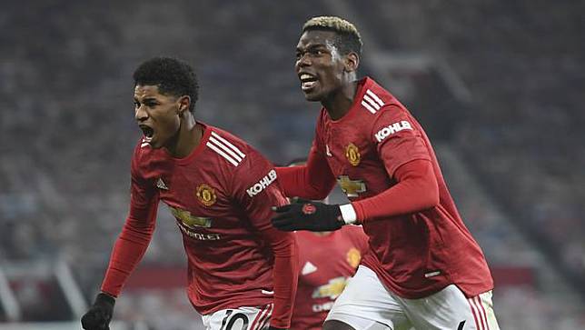 Penyerang Manchester United, Marcus Rashford (kiri) berselebrasi dengan rekannya Paul Pogba setelah mencetak gol pada menit 90+4 ke gawang Wolverhampton Wanderers pada pertandingan lanjutan Liga Inggris di Stadion Old Trafford, Rabu (30/12/2020). MU menang 1-0. (Michael Regan, Pool via AP)