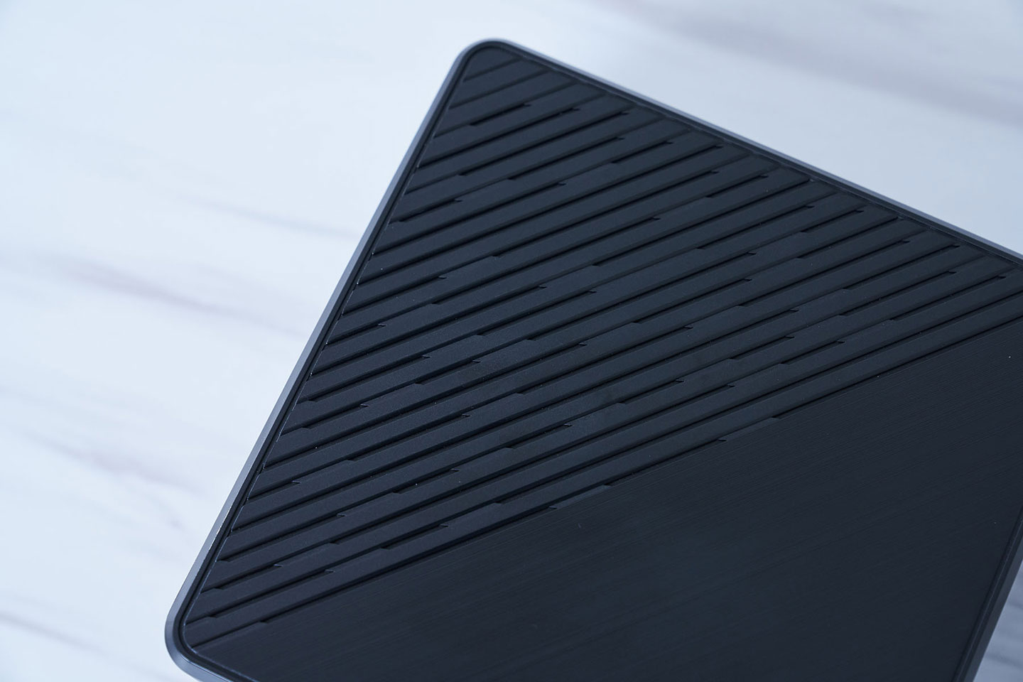 機身頂部的另一半結合了大面積的散熱孔佈局，並以同樣斜向的柵欄式設計。