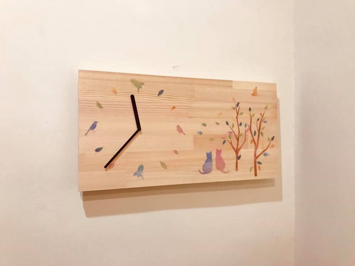 北歐風時鐘是透過電箱的螺絲加長，木片後面 2 顆螺絲，以鐵絲綁好後掛上。