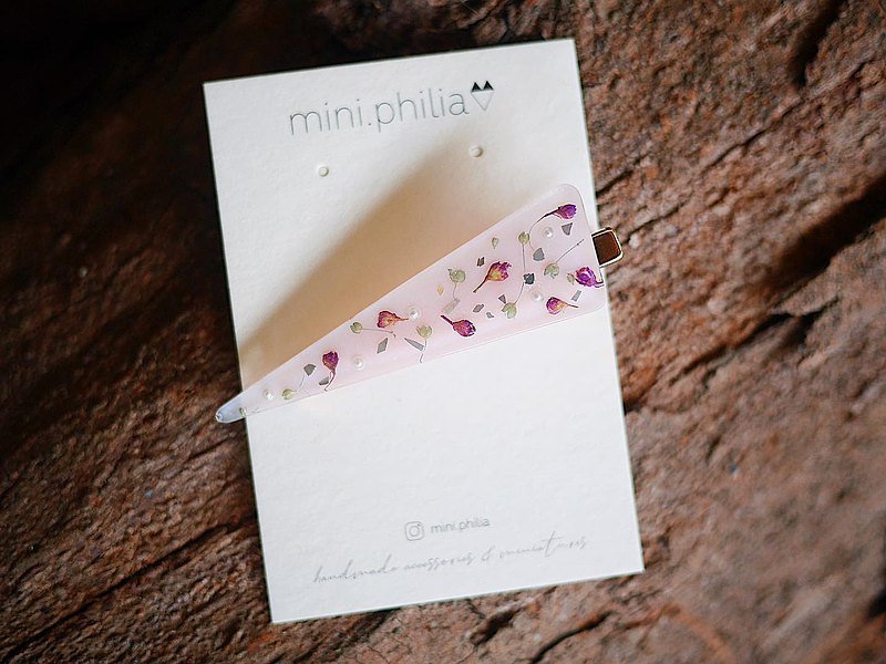 mini.philia真花飾品由人手製作，不論選材、設計和顏色調配均獨一無二。 以日本永生花和押花作主軸，把花材封存在日本UV膠內，再搭配精緻配件，呈現迷你花園感覺；把盛開掌握在手中，讓幸福穿戴在身上