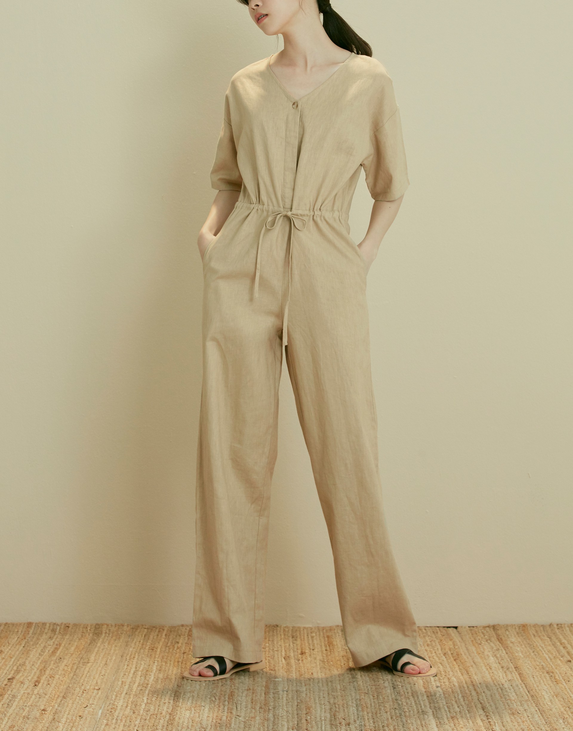 彈性：無 有一點挺度的質感棉麻布料、V領、前開一釦、兩顆暗釦設計、腰部附抽繩、連身褲版型