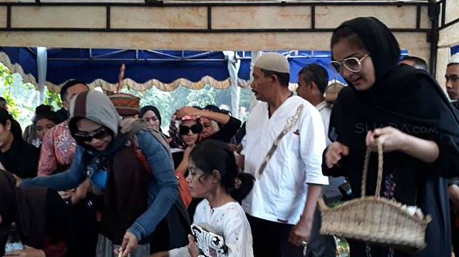 Penyanyi Ashanty tabur bunga di makam almarhum kakaknya di TPU Jeruk Purut, Jakarta Selatan, Selasa (13/2/2018). [suara.com/Wahyu]
