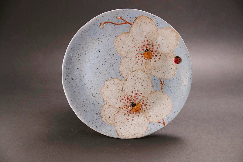 蘭花又稱「君子之花」，而臺灣適合蘭花生長，享有「蘭花王國」美譽。 創作者Jun生長於蘭花農家，善於詮釋花的姿態， 擷取實體蘭花並延著器皿構圖，高雅自然而大器， 花葉用色細膩，更顯高貴。 手作坯體及高溫