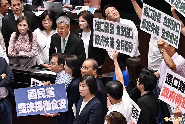 國民黨立法院黨團立委在議場發言台前舉牌，要求院長陳建仁為進口雞蛋爭議道歉。(記者劉信德攝)