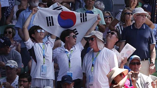 Pendukung Chung Hyeon mengibarkan bendera Korea Selatan di sela pertandingan melawan Tennys Sandgren. (REUTERS/Issei Kato)