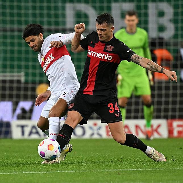 Granit Xhaka ® of Bayer Leverkusen vies with Mo Dahoud of Stuttgart during their German Cup quarterfinal match in Leverkusen, Germany, Feb. 6, 2024. (Photo by Ulrich Hufnagel/Xinhua)