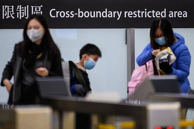 Commuters arriving in Hong Kong wear facemasks as they pass the cross boundary restricted area inside the high-speed train station connecting Hong Kong to mainland China during a public holiday in celebration of the Lunar New Year in Hong Kong on Jan. 28, 2020, as a preventative measure following a virus outbreak which began in the Chinese city of Wuhan. China on Jan. 28 urged its citizens to postpone travel abroad as it expanded unprecedented efforts to contain a viral outbreak that has killed 106 people and left other governments racing to pull their nationals from the contagion's epicenter. 