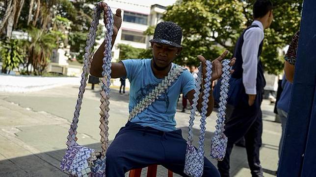 Dia bisa menggunakan 800 lembar uang untuk membuat sebuah tas jinjing, dan dengan nilai tukar yang sangat rendah jumlah itu hanya cukup dibelikan setengah kilogram beras. (AFP Photo/Federico Parra)