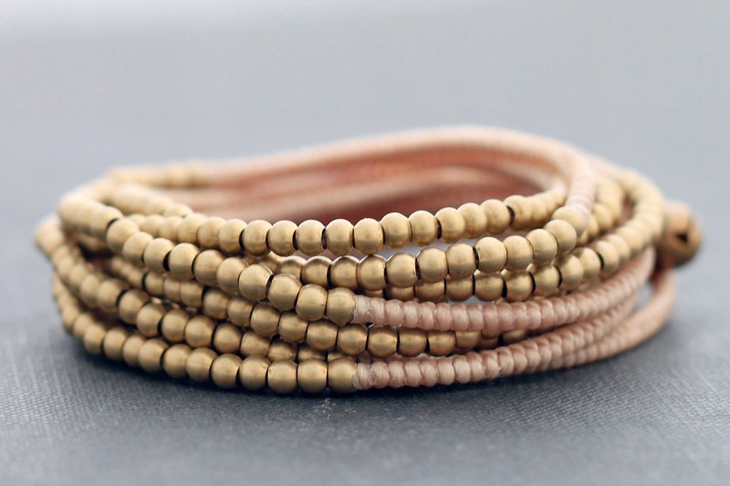 This is hand woven bracelet made with cream color cotton waxed cord weaved together with brass bead 