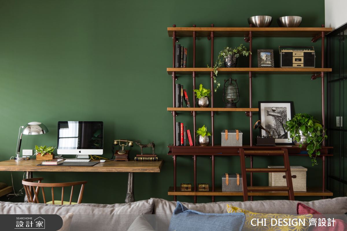 深綠色素雅的牆面沒有任何裝飾，選用了深木色系的簍空層架，配色相當亮眼，物品擺設建議留些空間突顯牆面色彩。