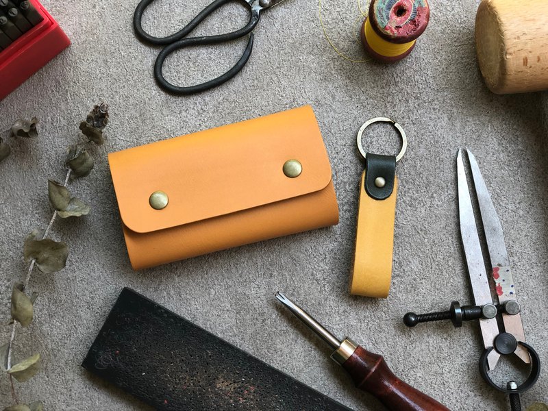 課程內容： 》完成捲餅票夾鑰匙包乙個，尺寸：闔起約7*11CM 》加贈鑰匙圈乙個，顏色可任選，現場教學打扣及敲字。 》皮革工具簡介 》皮件打洞 》手縫技巧 》五金安裝 》打磨皮邊 ☆上課備有鋼印可敲專