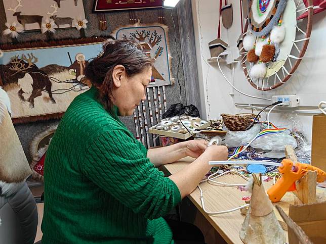 This photo taken with a mobile phone shows Uran making a piece of traditional Ewenki handicraft called “sun flower” at a handicraft workshop in Ewenki Autonomous Banner in the city of Hulun Buir, north China's Inner Mongolia Autonomous Region, Feb. 21, 2024. (Xinhua/Yu Jia)