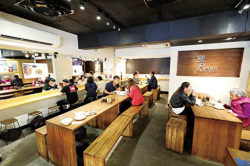 「雙月食品社」使用木質長桌與長凳，增添空間流暢感。（圖／于魯光攝）