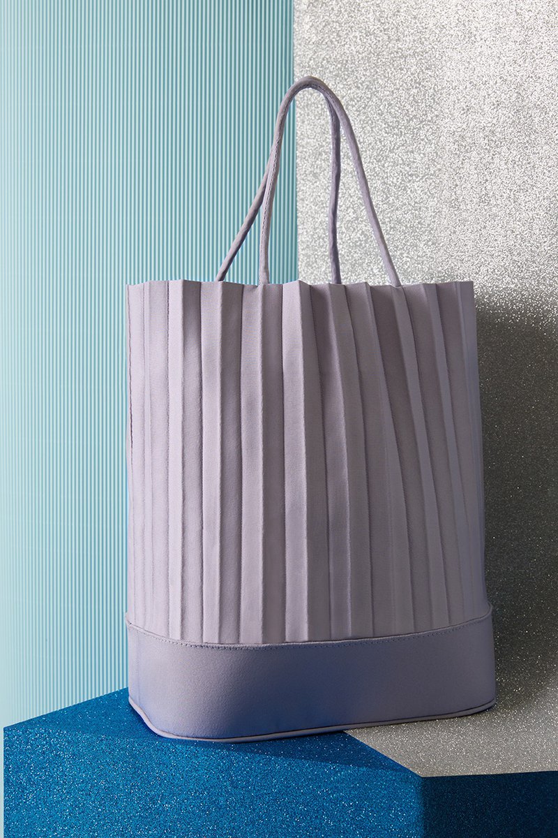 aPacklet手提包的頂部飾有標誌性褶皺，堅固的底座適合您的平板電腦和化妝包。