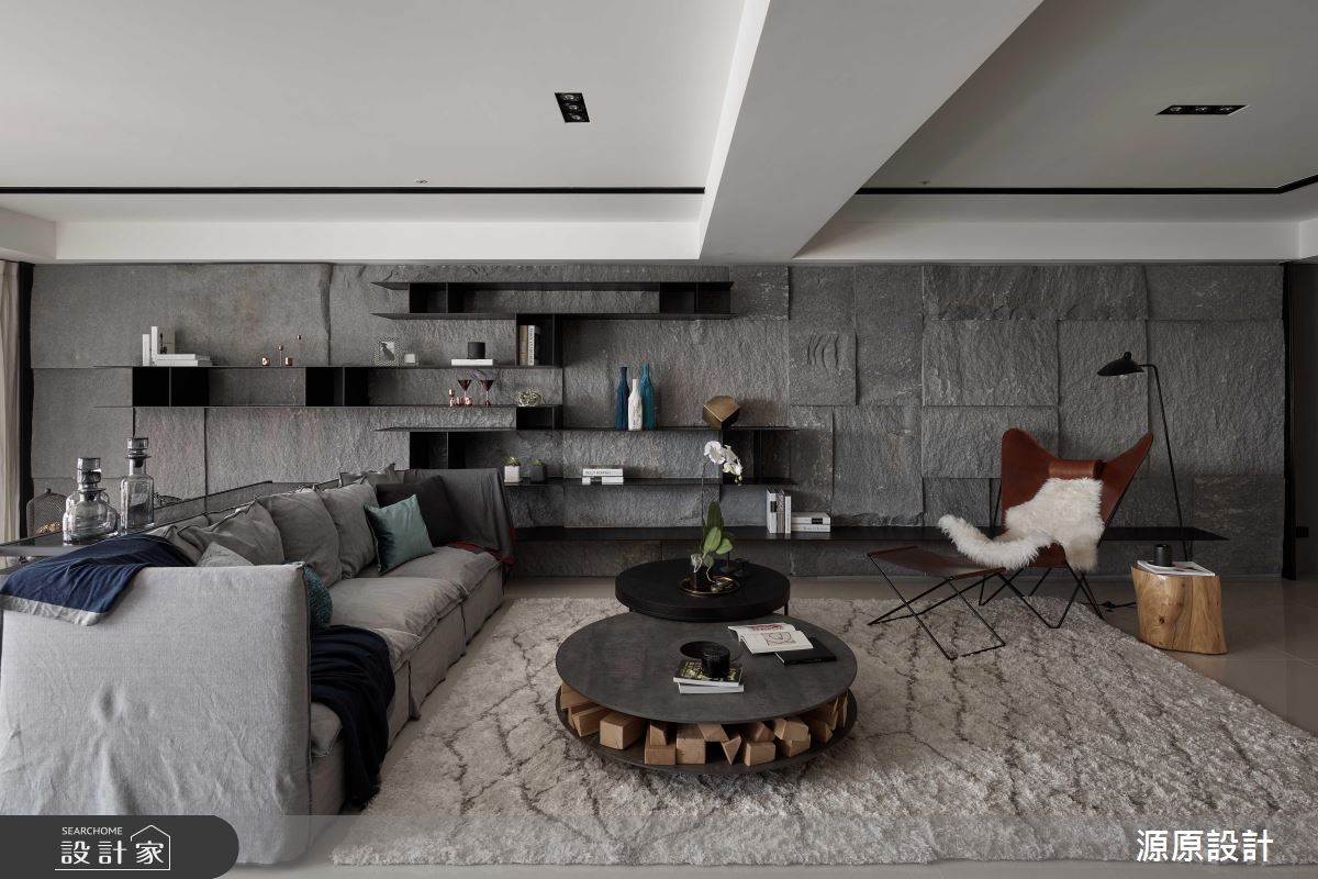 石材紋理的牆面，不規則的凹凸拼貼，將經常見於戶外公共空間的作法移到客廳，更有一種接近自然原始的感受。