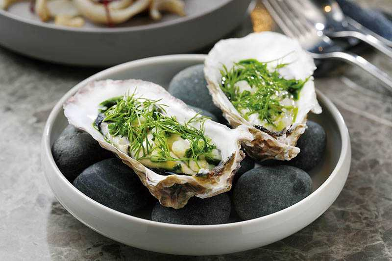 「火烤生蠔」帶著炭香的油脂包覆著生蠔，還加上以檸檬醃漬的青蘋果增加口感，圓潤又清爽。(580元)（圖／于魯光）