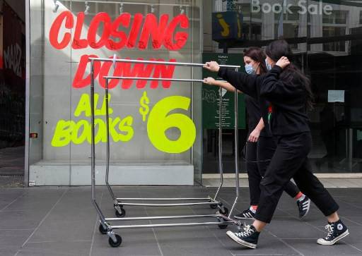 Workers push trolleys past an empty shop in Melbourne’s central business district on Monday after the state announced new restrictions as the city battles fresh outbreaks of the COVID-19 coronavirus. Australia's Victoria state imposed fresh, sweeping restrictions on Sunday, including a curfew in Melbourne for the next six weeks, a ban on weddings, and schools and universities going back online in the coming days.