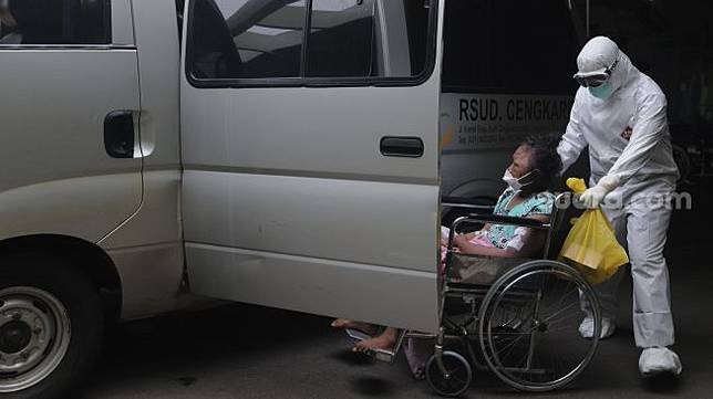 Petugas medis membawa pasien COVID-19 untuk dipindahkan ke ruang rawat inap dari selasr IGD RSUD Cengkareng, Jakarta, Rabu (23/6/2021). [Suara.com/Angga Budhiyanto]