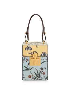 Inspired by vintage travel trunks, this elegant leather box bag is adorned with a lovely floral moti